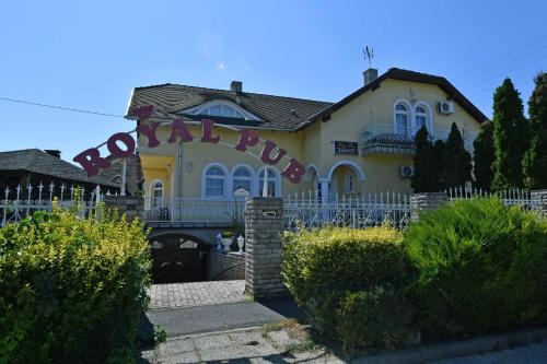 a yellow house with a fence in front of it at Royal Villa in Balatonfüred