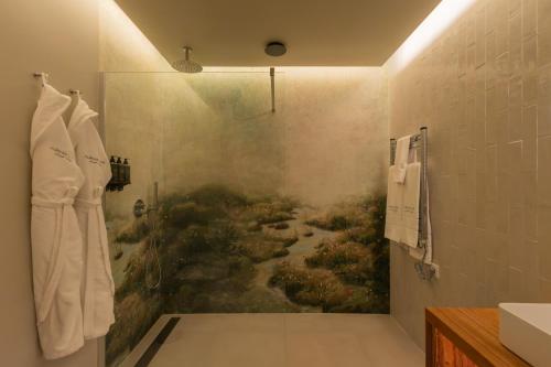 a bathroom with a shower with a painting on the wall at Furnas Lake Forest Living in Furnas