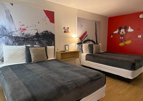 a bedroom with two beds and a painting on the wall at Lyrios Vacation Rentals - Legacy in Kissimmee