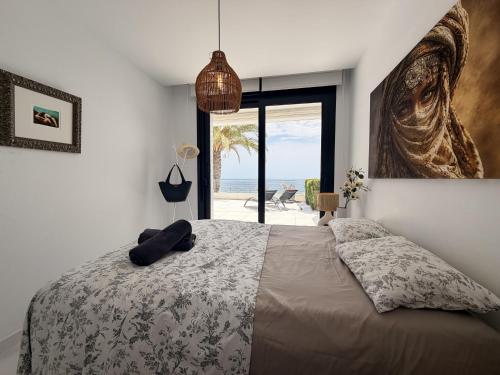 a bedroom with a bed with a view of the beach at Infinity View apartment in Arenales del Sol