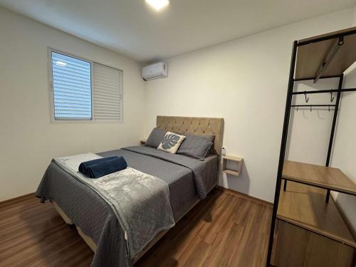 a small bedroom with a bed and a window at Edifício Forte dos Lagos in Toledo