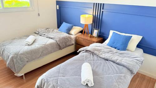 two beds sitting next to each other in a bedroom at Apartamento Geomundi proximo do lago e Shopping in Toledo