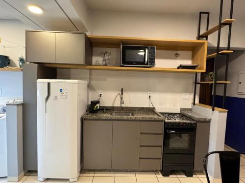 a small kitchen with a sink and a microwave at Studio UNI 15 - Unipar, Lago e Shopping in Toledo