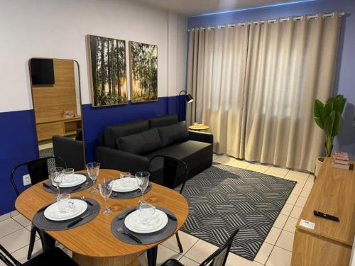 a living room with two tables and a couch at Studio UNI 15 - Unipar, Lago e Shopping in Toledo