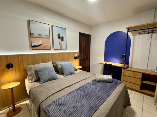 a bedroom with a bed with a blue and white blanket at Studio UNI 25 - Unipar, Lago e Shopping in Toledo