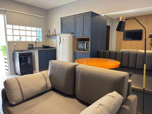 a living room with a couch and a kitchen at Studio UNI 102 - Unipar, Lago e Shopping in Toledo
