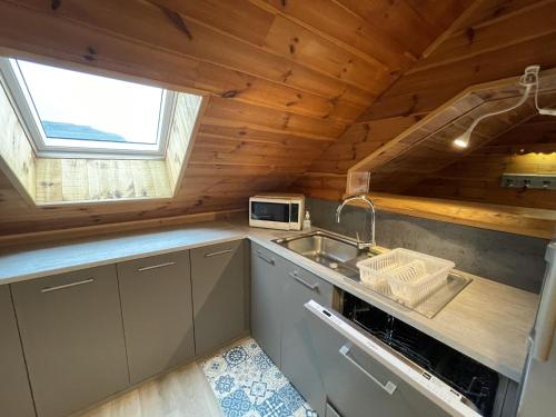 a small kitchen with a sink and a microwave at Appartement le bouc in Albepierre-Bredons