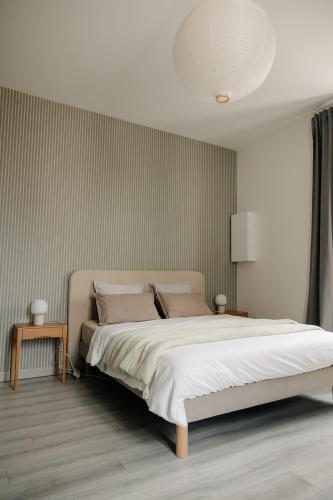 a bedroom with a large bed with white sheets at Studio élégant, central, pour 2 personnes in Pornic