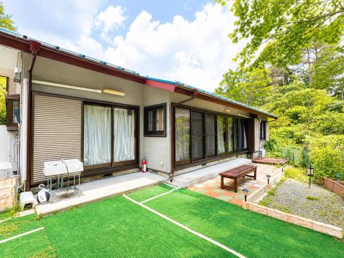a house with a patio and a grass yard at STAY FUJI b in Yamanakako