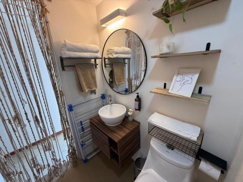 a bathroom with a sink and a mirror and a toilet at Seres Sayulita Beach Hotel in Sayulita