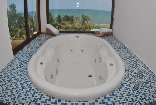 a bath tub in a bathroom with a view of the ocean at Hotel Istirinchá in Nautla