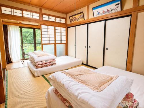 a bedroom with three beds in a room with windows at STAY FUJI b in Yamanakako