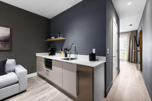 a kitchen with black walls and a sink and a couch at Vibras Wellness in Miami