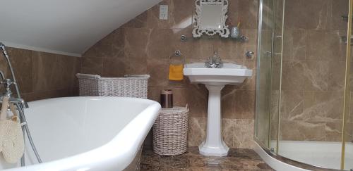 a bathroom with a tub and a sink and a shower at 5 Tamar in Findon