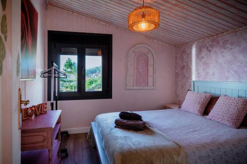 a bedroom with a bed and a desk and a window at A Constanza Portecelo in Rosal