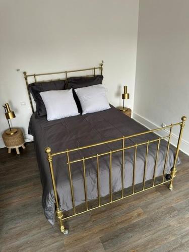 a bed with a metal frame in a bedroom at Floc & Sens in Chalons en Champagne