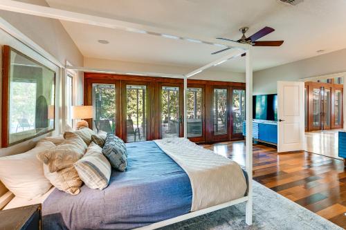 a bedroom with a bed with a ceiling fan at 4-Season Boathouse, Hot Tub! Guadalupe River Oasis in Seguin