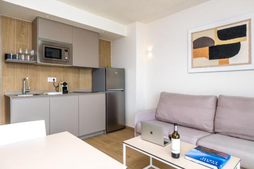 a living room with a couch and a kitchen at Don Cesar Boutique Apartments in Benidorm