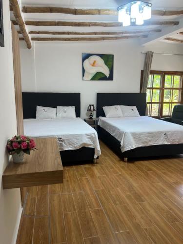 a bedroom with two beds and a wooden floor at Jardín Secreto in San Martín