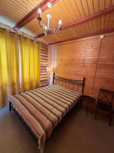 a bedroom with a bed in a room with wooden walls at Villa Shoda in Oni