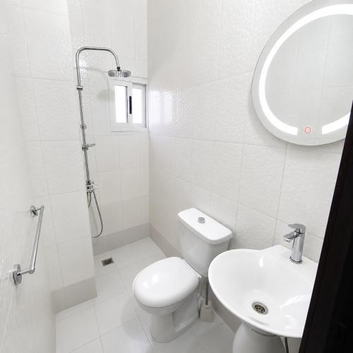 a white bathroom with a toilet and a sink at Studio américain Confort avec piscine in Abidjan