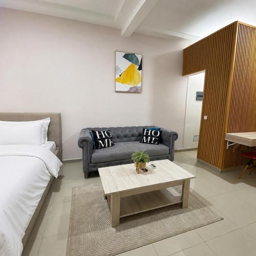 a living room with a couch and a coffee table at Studio américain Confort avec piscine in Abidjan