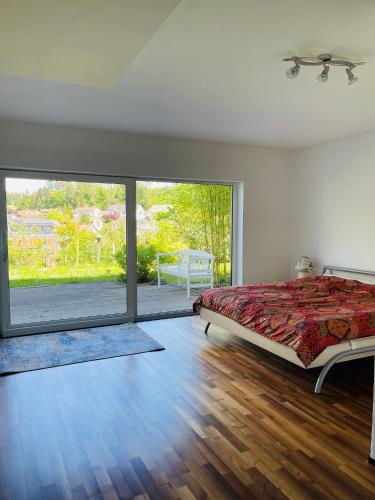 a bedroom with a bed and a large window at Blick ins Grüne in Daisendorf