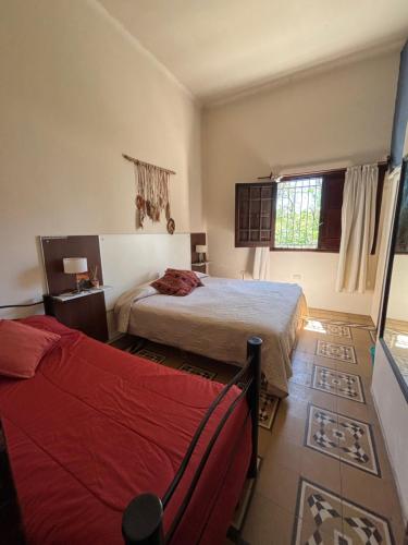 a bedroom with two beds and a window at aromasdelpandeazucar in Unquillo