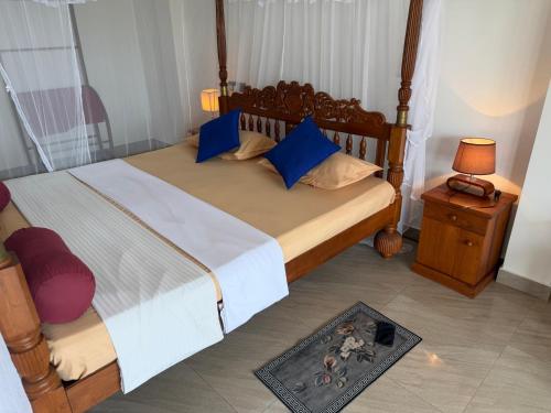 a bedroom with a large bed with blue pillows at Coral Reef Guest in Beruwala