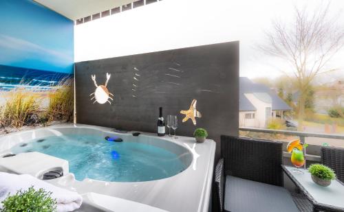 a hot tub on a patio with a table and chairs at Hotel Am Kurpark Späth in Bad Windsheim
