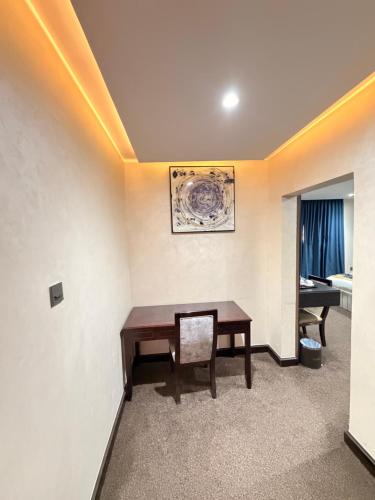 a room with a wooden table and a chair at Sonia Hotel in Accra