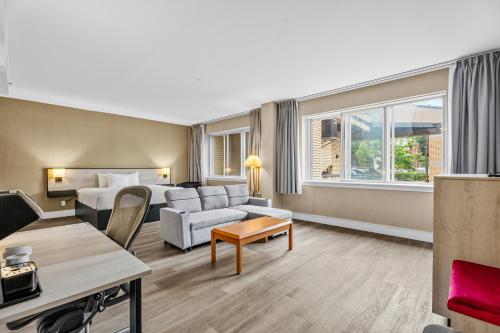 a hotel room with a bed and a couch at Ramada Plaza by Wyndham Montreal in Montreal