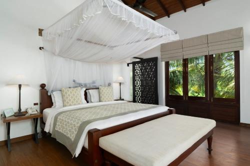 a white bedroom with two beds and a window at Aavya Cove Villas by Aahaasa in Balapitiya