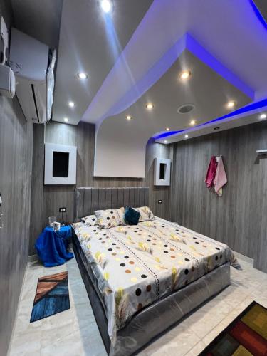 a bedroom with a large bed with a purple ceiling at Mazen Zakaria apartment in Port Said