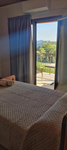 a bedroom with a bed and a window with a view at PetroLithos Traditional Suites in Agros