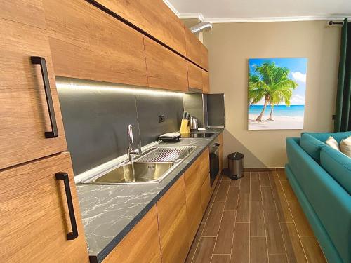 a kitchen with a sink and a blue couch at EKA Luxury Beachfront Apartments in Vlorë