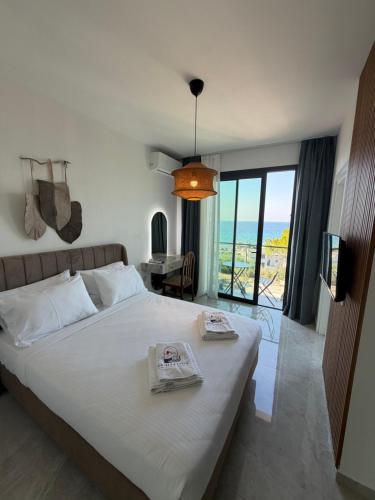 a bedroom with a bed with a view of the ocean at Vasilia Cove Boutique Hotel in Nicosia