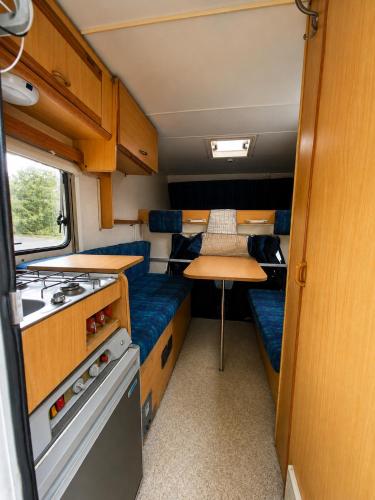 a small kitchen with a table and a stove in an rv at Camping Principata in Brungaj