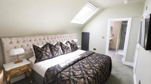 a bedroom with a large bed and a skylight at Bellinter House Hotel & Spa in Navan