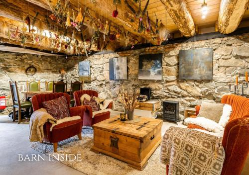 a living room with chairs and a stone wall at WonderInn Riverside in Årnes