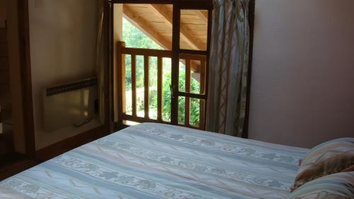 a bedroom with a bed and a window with a view at Gite des Carcis in Ganac
