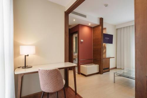 a room with a desk with a chair and a mirror at Dorma León in León