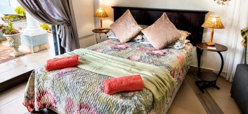 a bedroom with a bed with pillows on it at Peacock Cove Self Catering Studio in Gordonʼs Bay
