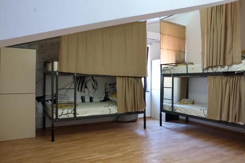 two bunk beds in a room with wooden floors at Drenak Hostel in Skopje