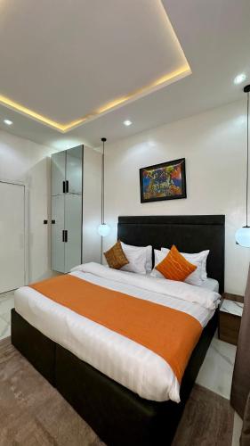 a bedroom with a large bed with an orange blanket at Flat in lekki2 bed apartment in Lekki