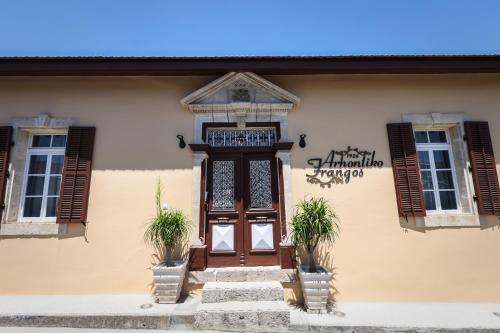 a building with a wooden door and two windows at Arhontiko Frangos in Kato Drys
