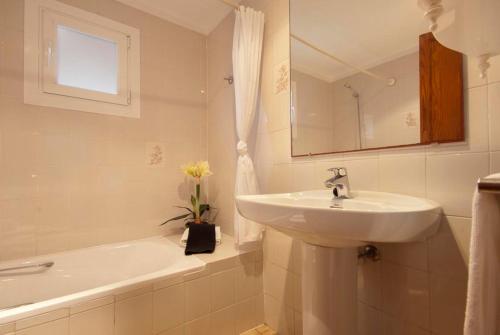 a white bathroom with a sink and a bath tub at PINOS ALTOS 01 in Cala de Sant Vicenc