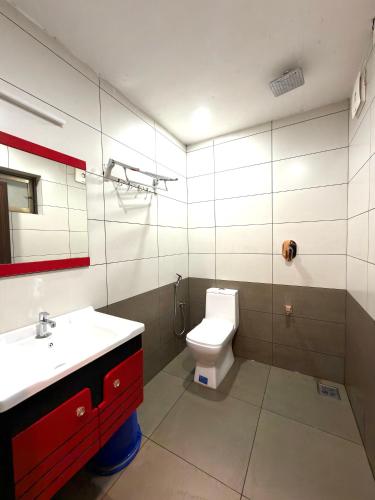 a bathroom with a toilet and a sink and a mirror at Wayanad Way Resort in Koroth