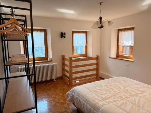 a bedroom with a bunk bed and a room with a ladder at Appartamento Girasole - Cadore Apartments in Candide