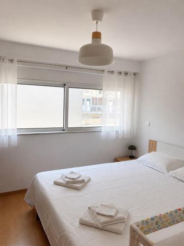 a white bedroom with a bed with towels on it at Downtown View Apartment - Rhodes in Rhodes Town